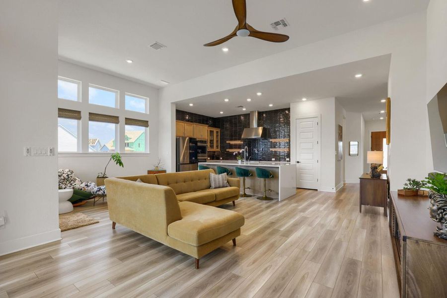 An inviting open-concept living space featuring the modern kitchen flows seamlessly into the relaxed seating area - perfect for entertaining.
