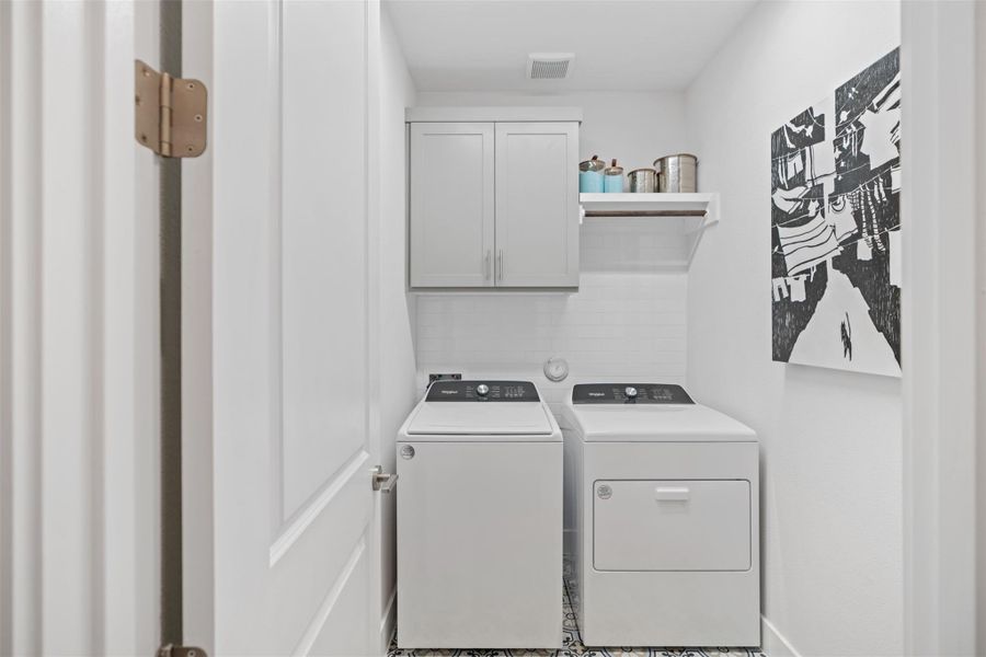 Washroom featuring washer and clothes dryer and cabinet space. The photos shown are of a completed home with the same floor plan and may not reflect the exact finishes, features, or layout of the home currently under construction.