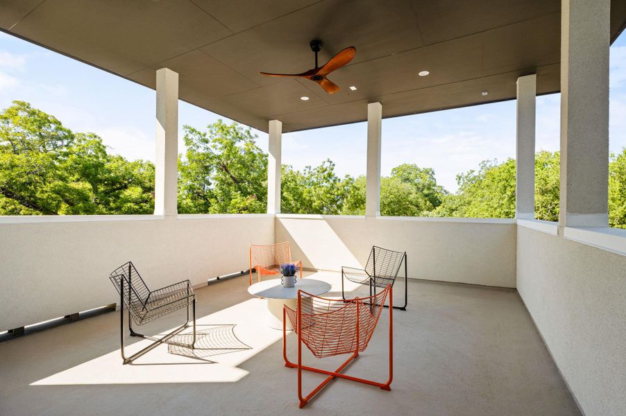 Elevated covered balcony overlooks a dense canopy of mature green trees. Elevated covered balcony overlooks a dense canopy of mature green trees.