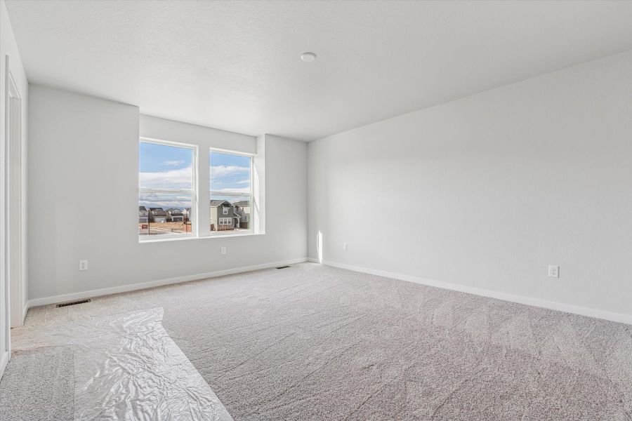 A room with a carpet and a window.