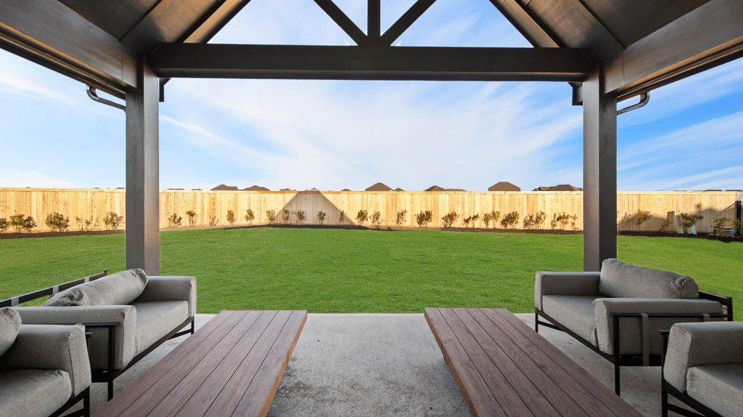 Your backyard oasis awaits! Featuring a massive yard with lush green grass, a wide covered patio with comfortable seating, and warm outdoor lighting. The patio creates a cozy, all-weather gathering space that overlooks the open yard, perfect for relaxing or entertaining. Your backyard oasis awaits! Featuring a massive yard with lush green grass, a wide covered patio with comfortable seating, and warm outdoor lighting. The patio creates a cozy, all-weather gathering space that overlooks the open yard, perfect for relaxing or entertaining.