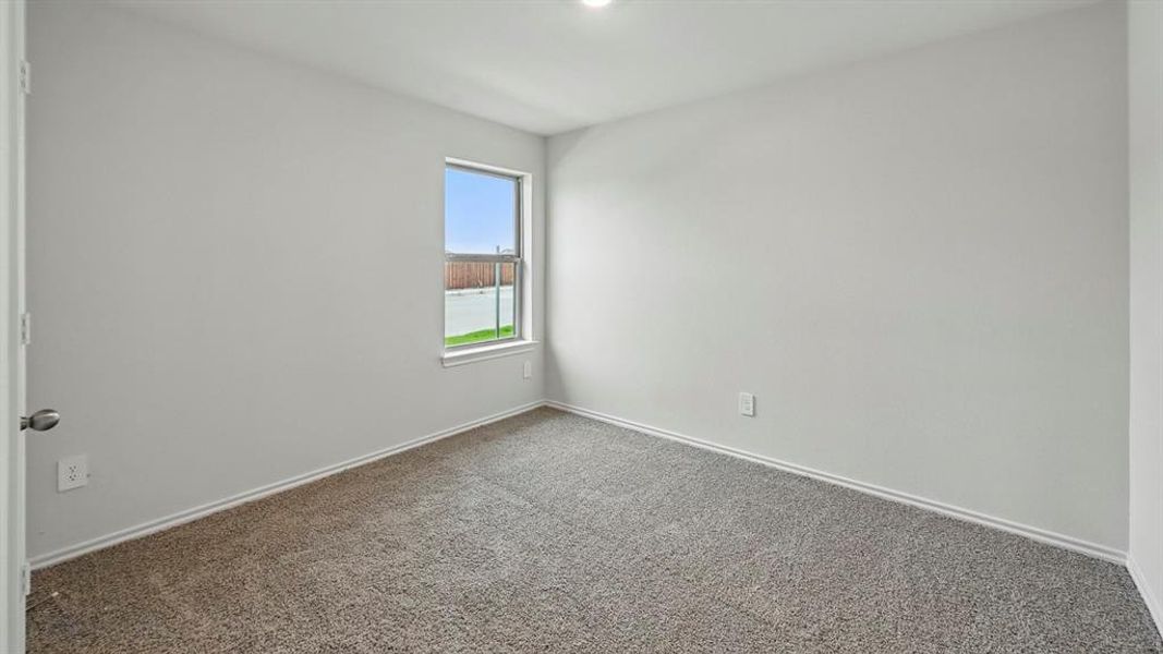 Spare room featuring carpet and baseboards