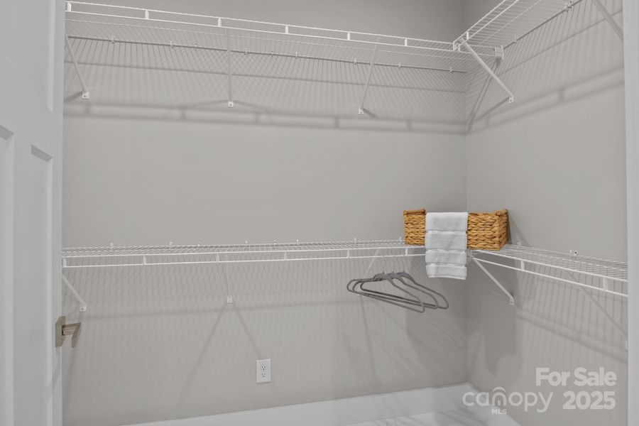 One of two spacious walk-in closets in the primary bedroom, offering generous storage and easy organization.