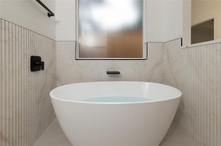Full bathroom with tile patterned flooring and a soaking tub