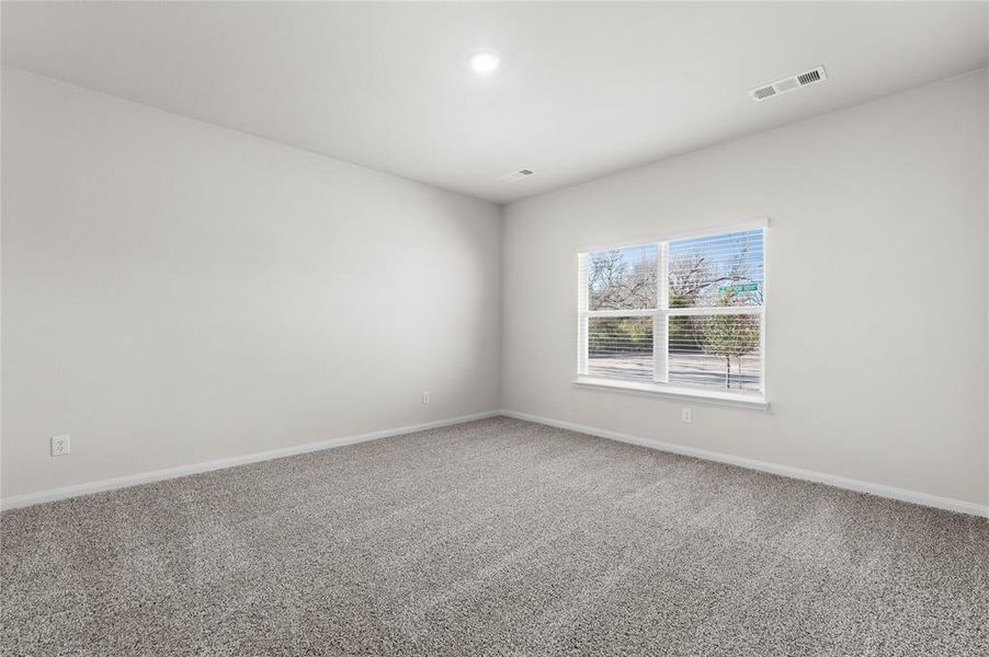 Carpeted empty room with baseboards and visible vents