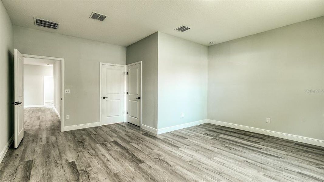 The primary bedroom suite provides ample living space with room for a sitting area and a spacious walk-in closet.