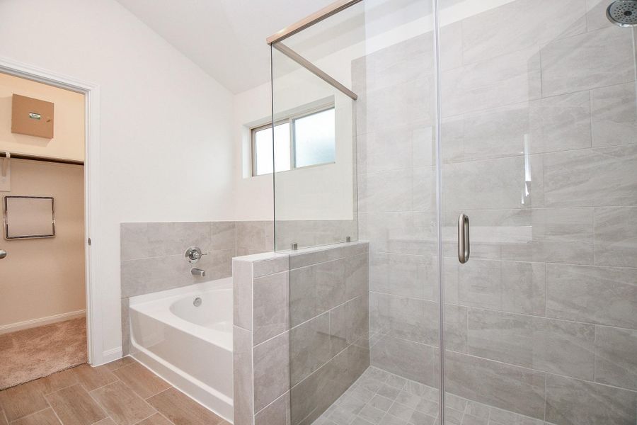 Here is the separate soaking tub and and a beautiful shower with a glass door. Notice the beautifully detailed tile as the shower wall.