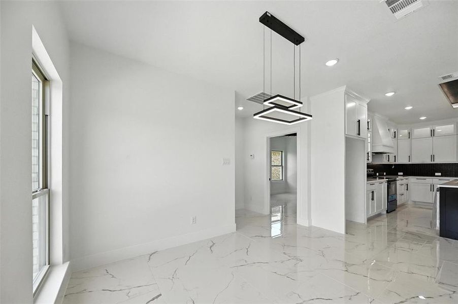 Kitchen with light marble finish flooring, white cabinetry, tasteful backsplash, electric stove, and pendant lighting