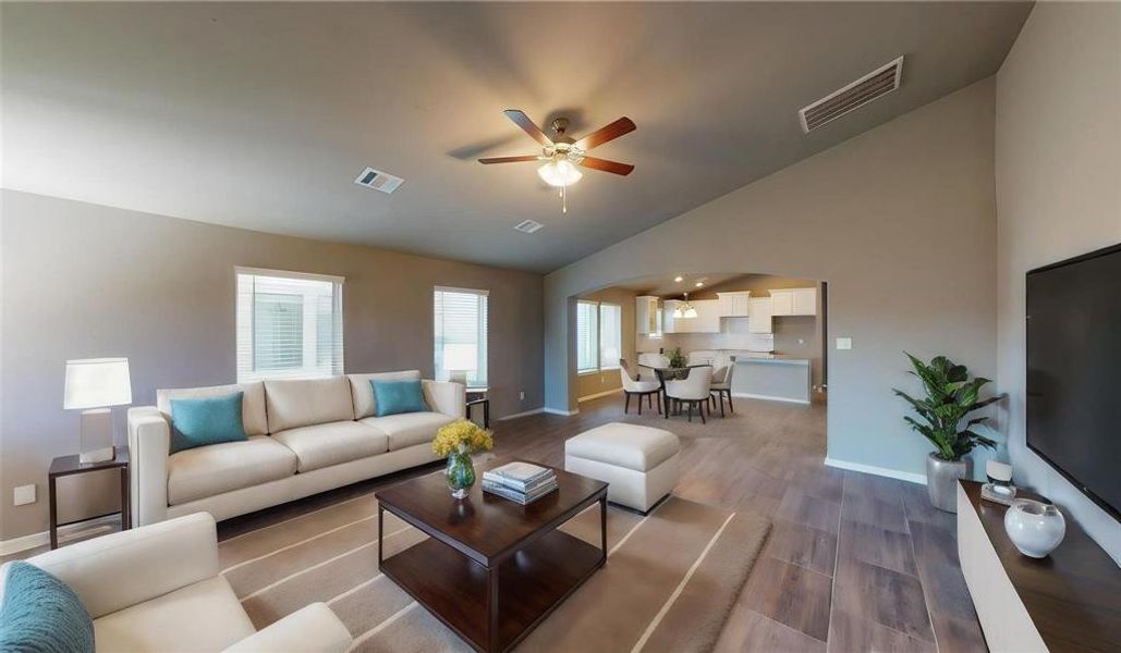 Enjoy a seamless blend of style and functionality in this expansive living area, highlighted by its sleek tile floors, modern ceiling fan, and large windows that flood the space with natural light. The open floor plan facilitates effortless movement between the living room and the kitchen, perfect for both everyday living and entertaining guests. This is a picture of an Elise Floor Plan with another Saratoga Homes.