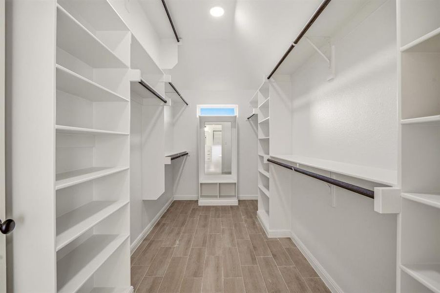 Walk in closet with wood finish floors