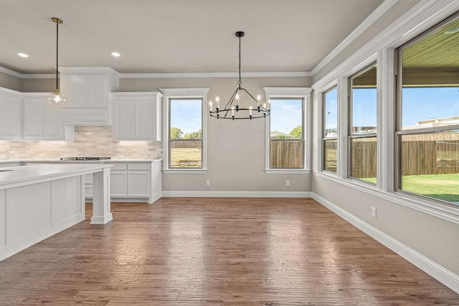 Unfurnished dining area with ornamental molding, dark wood finished floors, a chandelier, and recessed lighting Unfurnished dining area with ornamental molding, dark wood finished floors, a chandelier, and recessed lighting