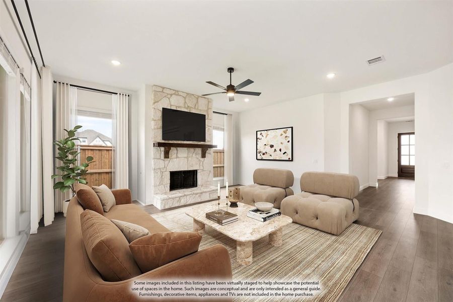 Living room with stone fireplace, ceiling fan, hardwood floors, and neutral-toned furniture seating area