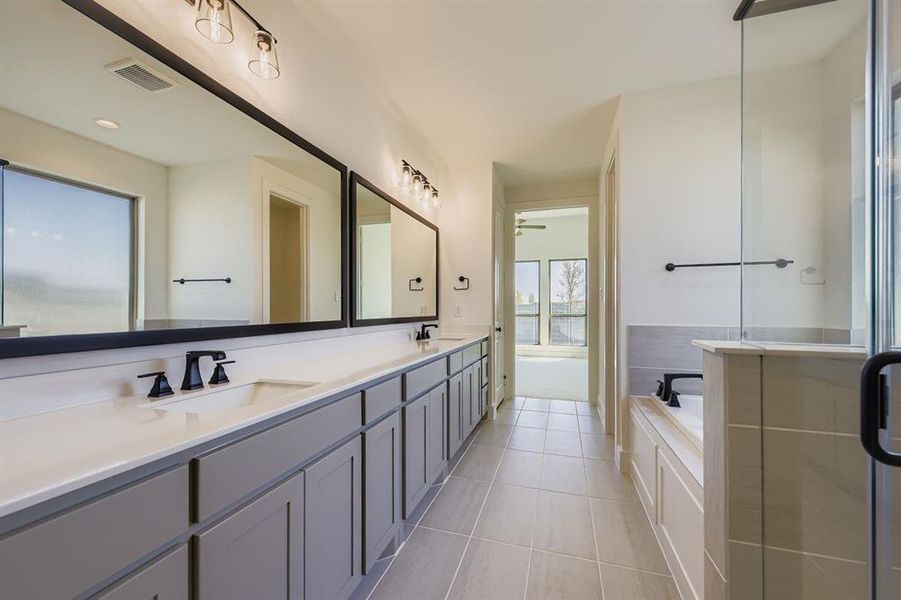 Bathroom with double vanity, a garden tub, and light tile patterned flooring Bathroom with double vanity, a garden tub, and light tile patterned flooring