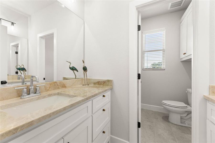 Half bath featuring vanity and light tile patterned floors Half bath featuring vanity and light tile patterned floors