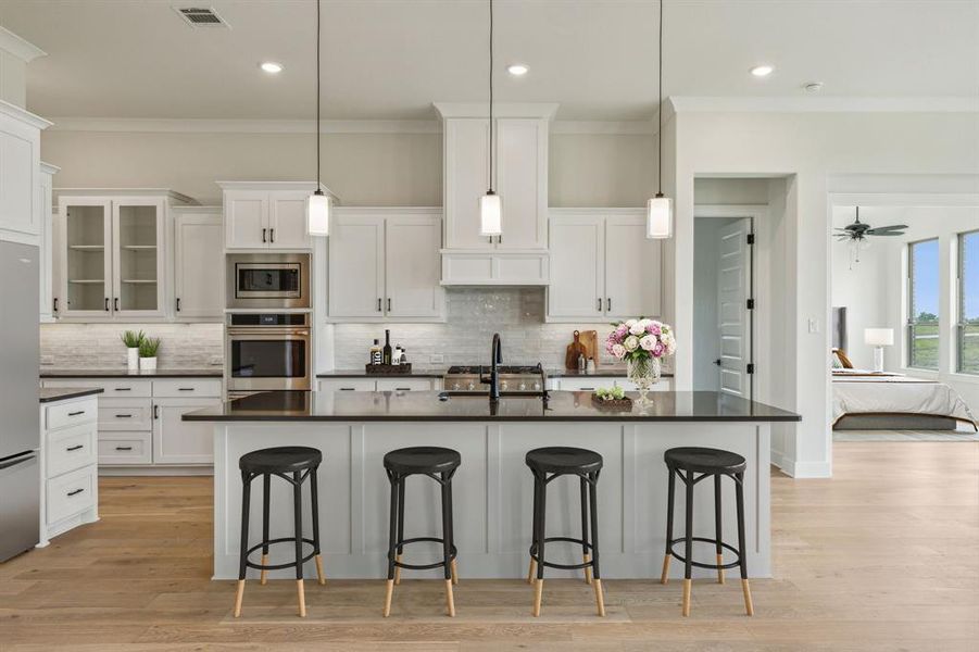 Kitchen featuring light wood-type flooring, appliances with stainless steel finishes, and white cabinetry *VIRTUAL STAGING