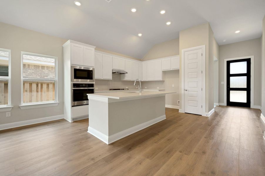 Kitchen featuring plenty of natural light, recessed lighting, stainless steel appliances, white cabinetry, and light wood-type flooring