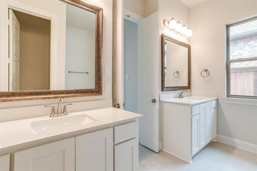 Bathroom with tile patterned flooring and dual vanity