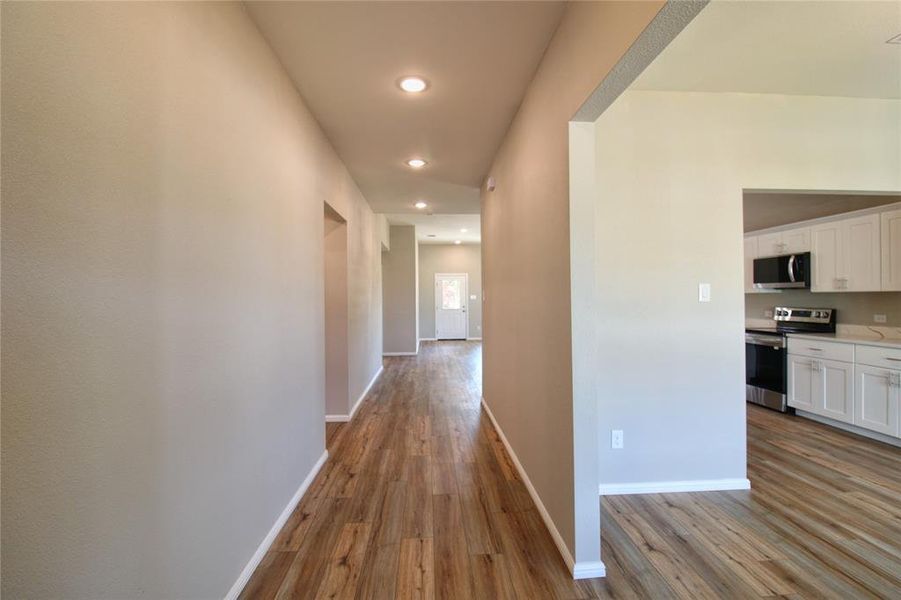 Corridor with dark wood finished floors and recessed lighting