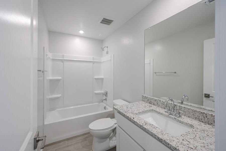 A bathroom with a tub sink and toilet.