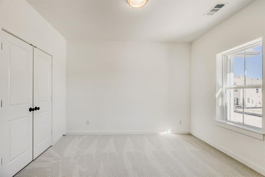 Unfurnished bedroom featuring light colored carpet and a closet