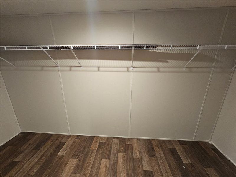 Spacious closet with dark wood-type flooring Spacious closet with dark wood-type flooring