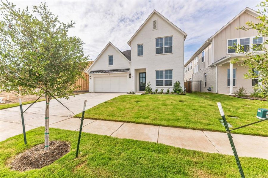 View of front of property featuring a garage and a front yard