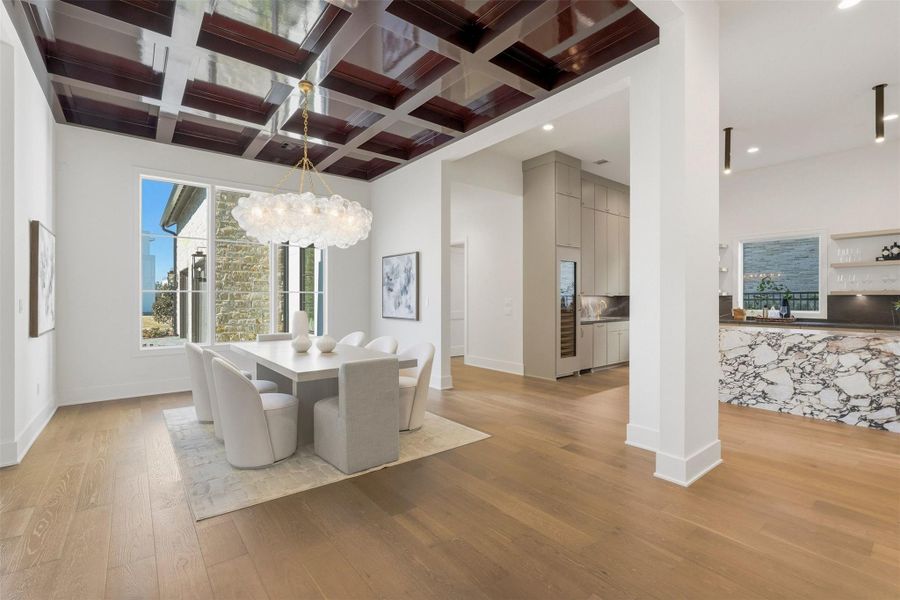 The open layout connects this formal dining space to a contemporary bar with a marble waterfall island and sleek cabinetry for refined social affairs. The open layout connects this formal dining space to a contemporary bar with a marble waterfall island and sleek cabinetry for refined social affairs.