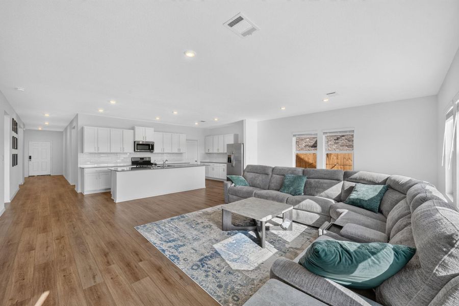 An open-concept living space integrates a modern kitchen with sleek appliances and a comfortable seating area. An open-concept living space integrates a modern kitchen with sleek appliances and a comfortable seating area.