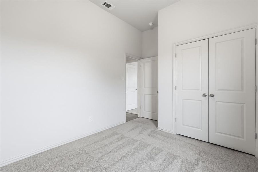 Unfurnished bedroom featuring light colored carpet and a closet