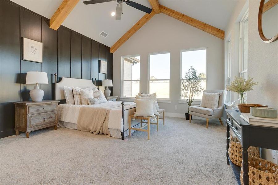 Carpeted bedroom with beamed ceiling, high vaulted ceiling, and ceiling fan