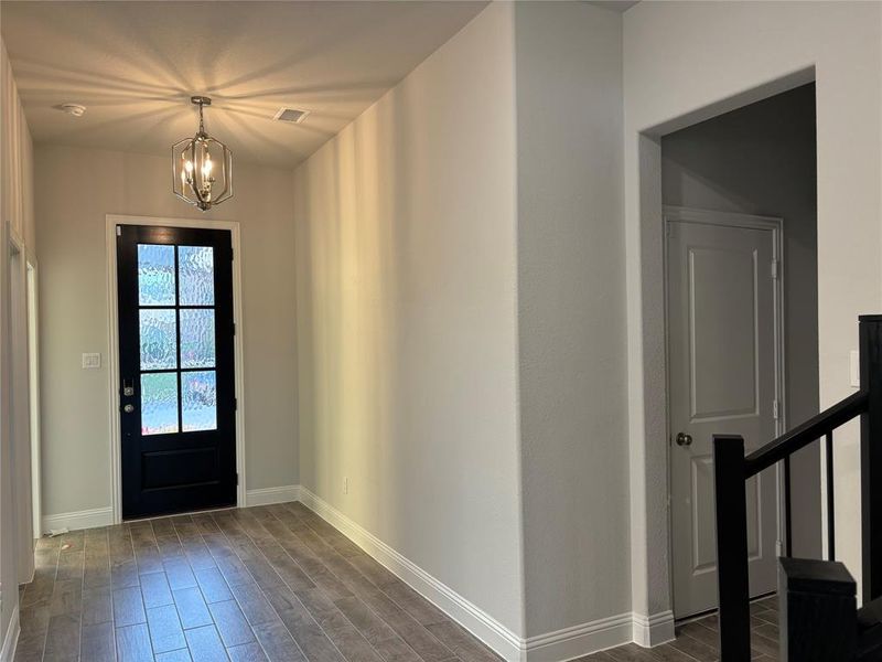 Foyer featuring dark hardwood / wood-style floors and a chandelier