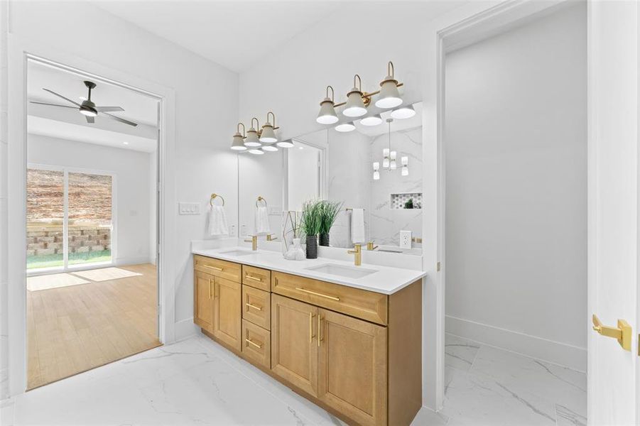 Bathroom with double vanity, light marble finish flooring, and ceiling fan