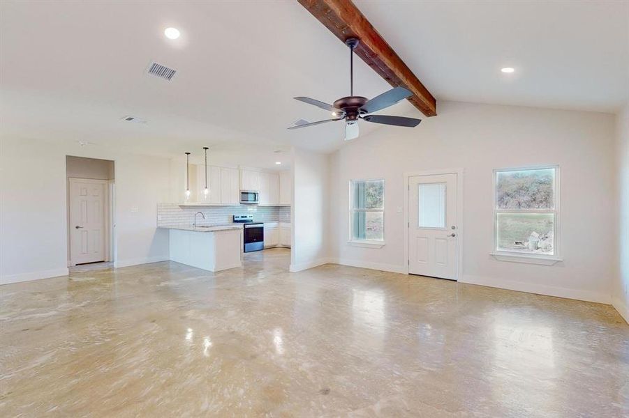 Unfurnished living room with vaulted ceiling with beams, ceiling fan, and sink