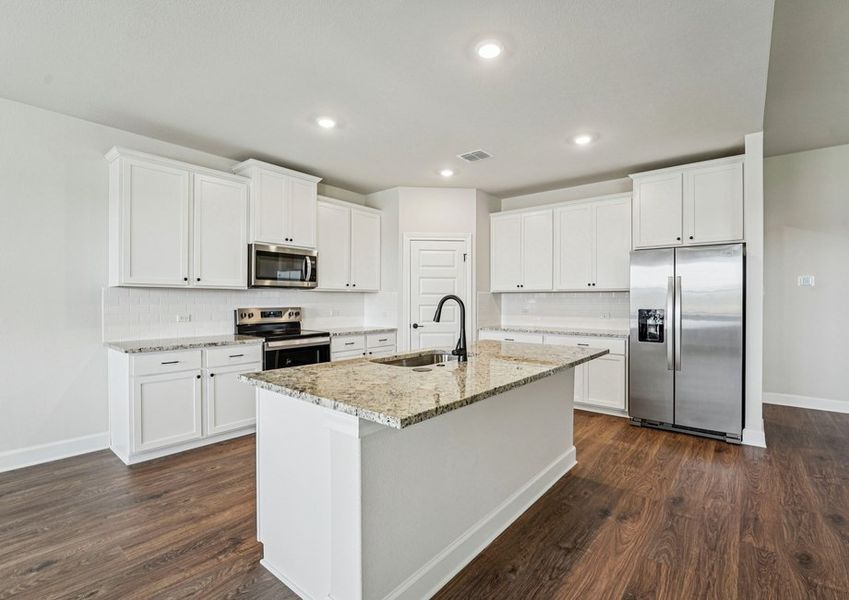 Kitchen featuring a granite island, white cabinetry, and stainless steel appliances with wood-look vinyl flooring. Kitchen featuring a granite island, white cabinetry, and stainless steel appliances with wood-look vinyl flooring.