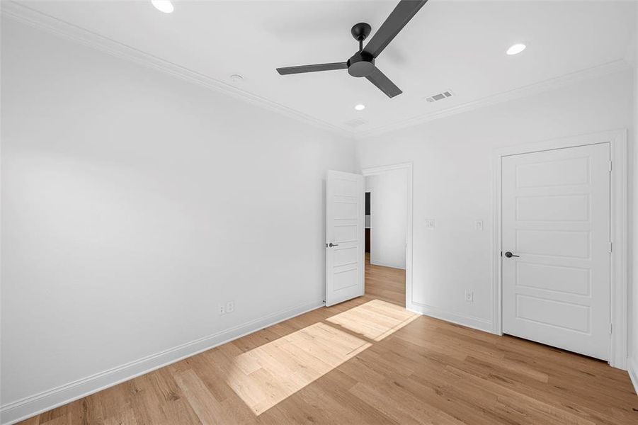 Unfurnished bedroom with crown molding, light wood-type flooring, a ceiling fan, and recessed lighting Unfurnished bedroom with crown molding, light wood-type flooring, a ceiling fan, and recessed lighting