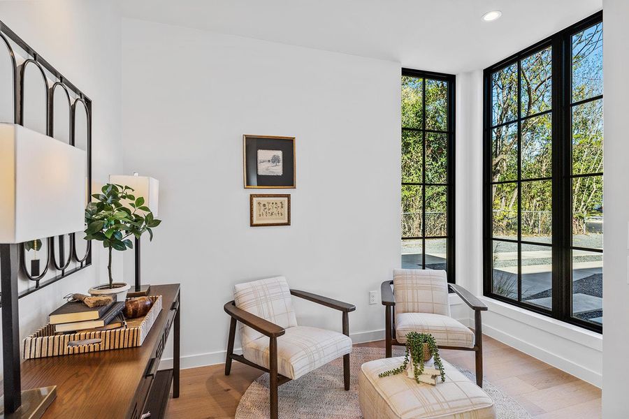 Sitting room featuring plenty of natural light, wood finished floors, recessed lighting, and a wall of windows