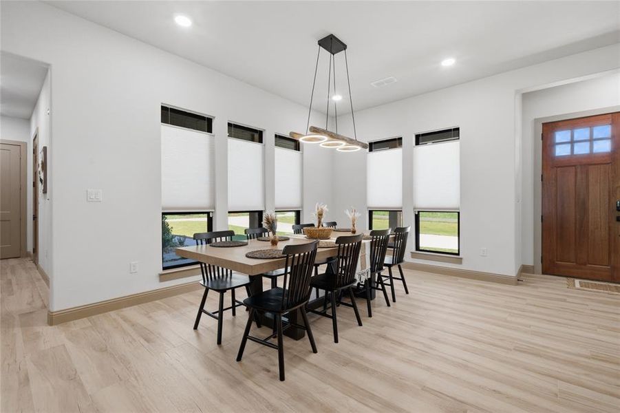 Dining area featuring light wood-finish flooring and multiple recessed ceiling lights