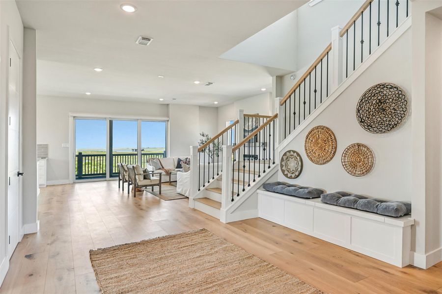 The staircase makes a striking statement with black iron spindles and timeless architectural detail. A built in bench adds charm and convenience while complementing the elevated design.