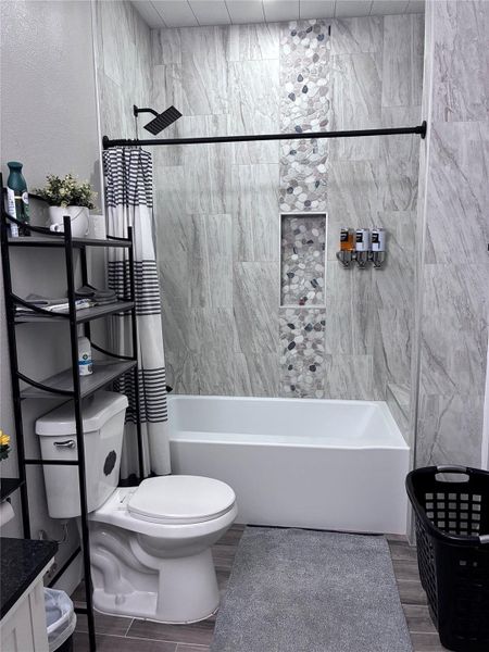 Master Full bath with Tile Surround shower / tub combo, vanity, and wood tiled floors