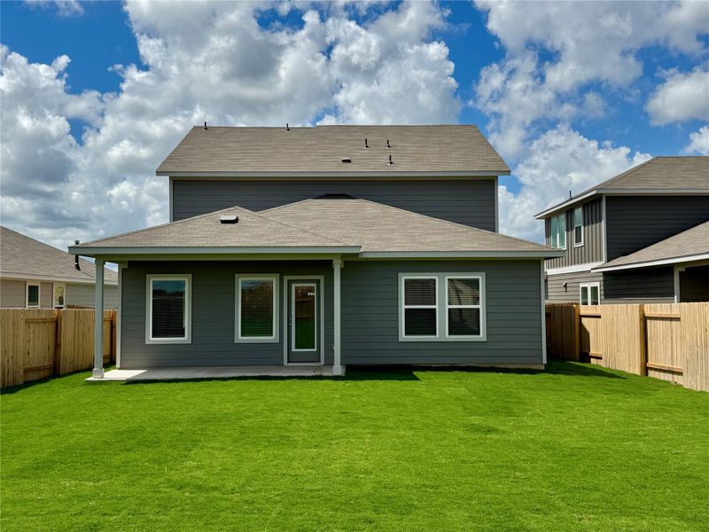 Back of property with a fenced backyard, a shingled roof, and a patio area Back of property with a fenced backyard, a shingled roof, and a patio area