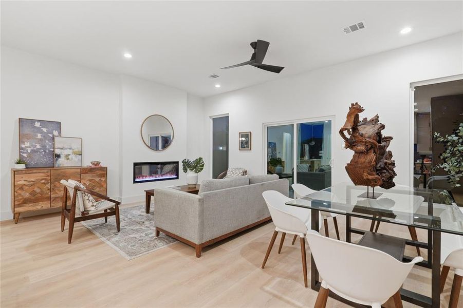 Bright open-concept living space featuring wood-finish flooring, recessed lighting, and a modern ceiling fan