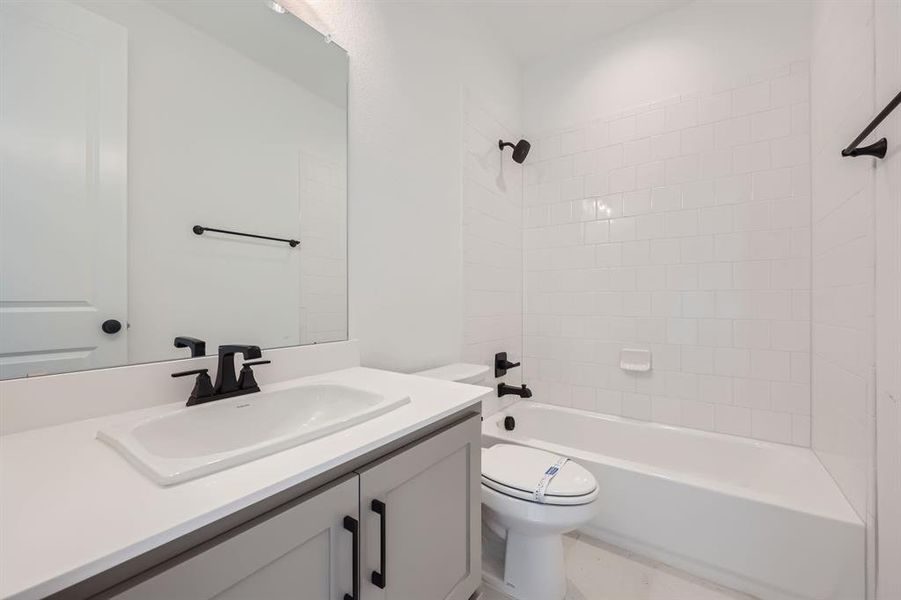 Full bathroom with vanity, toilet, and tiled shower / bath