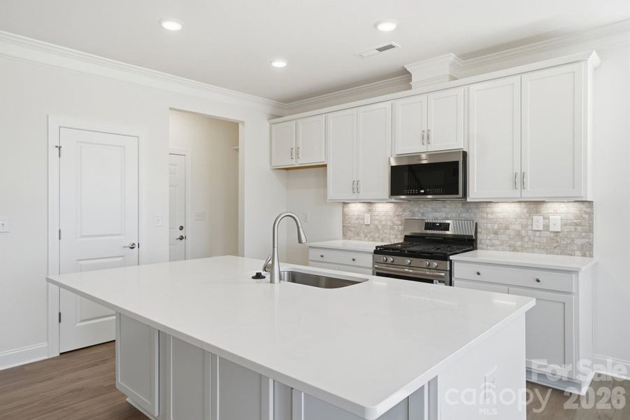 Kitchen with all white cabinets, island and quartz countertops