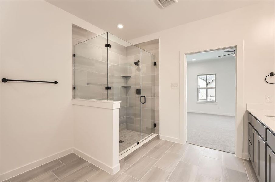 Bathroom with ceiling fan, vanity, and a shower with shower door