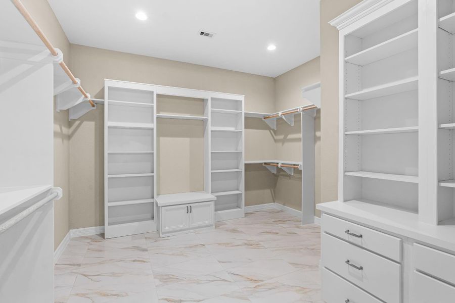 Expansive walk-in closet with built-in shelving, drawers, and abundant storage space, designed for organization and convenience.