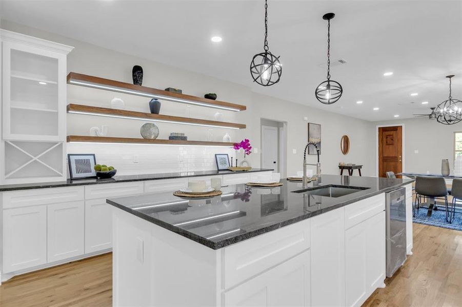Kitchen featuring white cabinetry, backsplash, open shelves, a spacious island, and recessed lighting