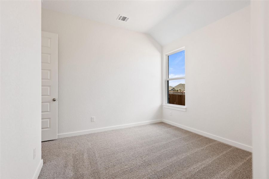 Unfurnished room featuring light colored carpet and lofted ceiling