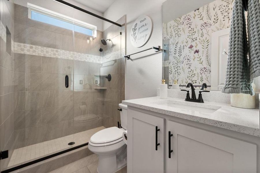 Full bath with vanity, a stall shower, and light tile patterned floors