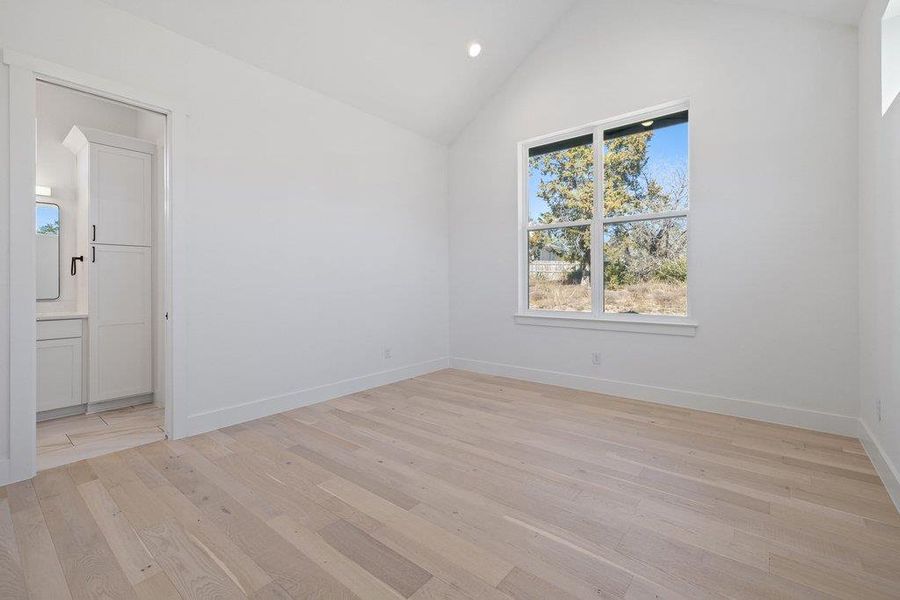 Unfurnished room with recessed lighting, lofted ceiling, and light wood-style flooring