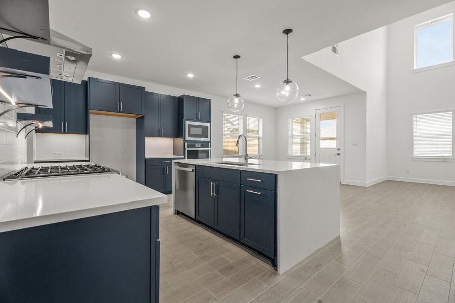 Open kitchen with blue cabinets and quartz countertops
